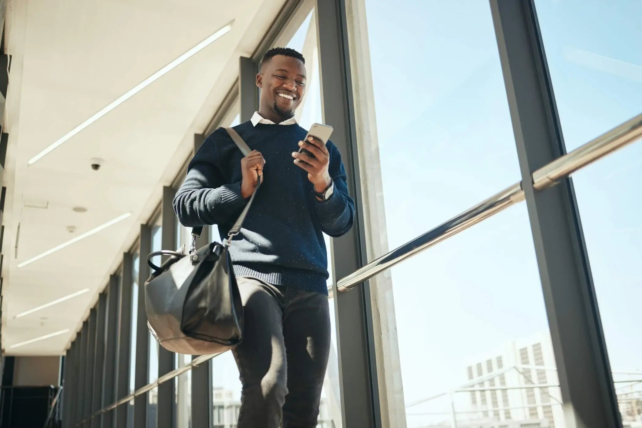 business man looking at his phone in an international airport