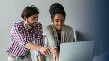 two program managers looking at different gift card options on a laptop